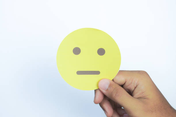 Man holding  an neutral emoji face.