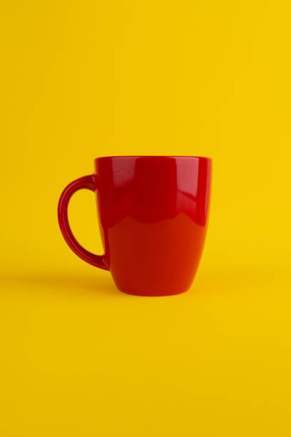 istock Red coffee or tea cups on yellow background. Red mug. Corporate color. ceramic mug 2161870263