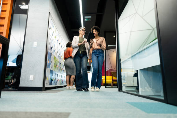istock Businesswomen walking and using digital tablet at office 2161871222