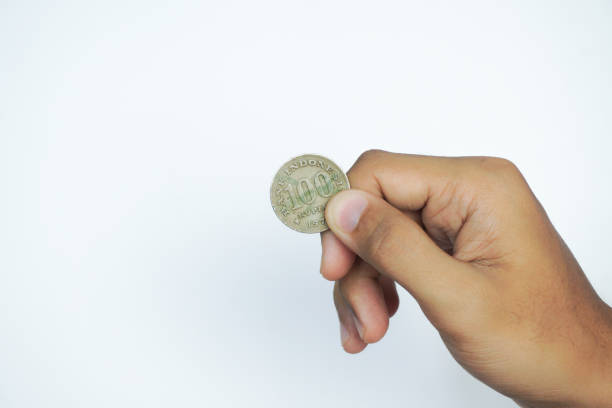 istock Hand holding Old Indonesian 100 rupiah coin. Published in 1978. isolated on white background 2161872830