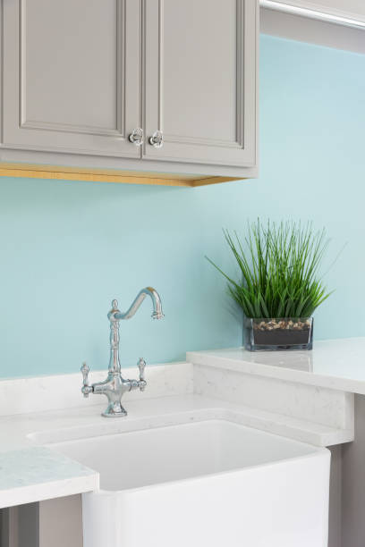istock A laundry room with brown cabinets and an apron sink. 2161873039