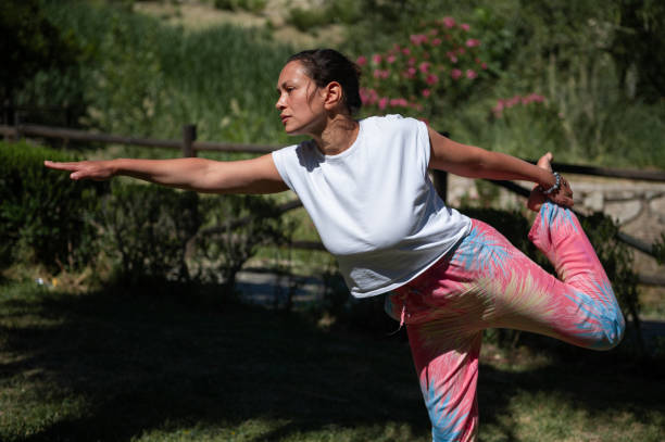 istock Woman practicing yoga outdoors in a peaceful garden setting 2161874899