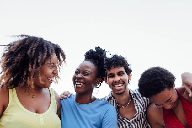 istock Four smiling mixed race friends standing and looking down at camera 2161875480