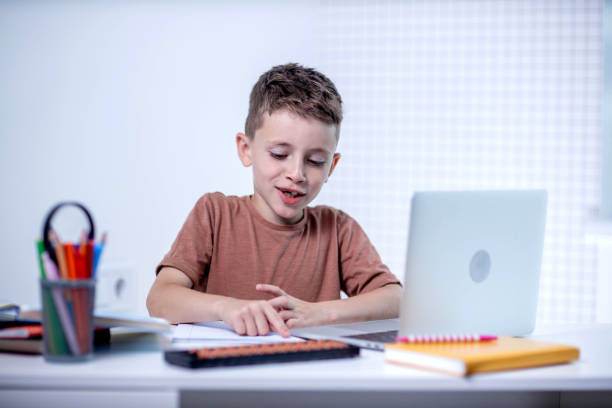 istock Boy reading book at the table at home 2161876012