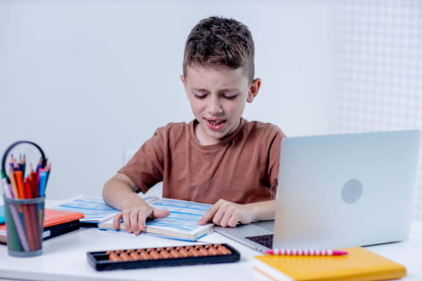 istock Boy reading book at the table at home 2161876107