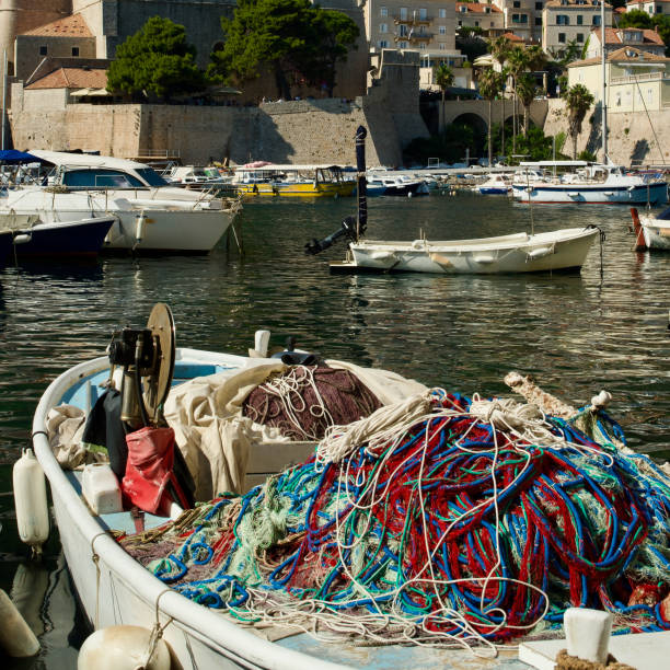 istock small boat with colourful fishing nets piled up 2161877675