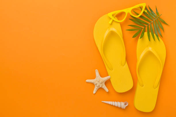 istock Bright yellow flip-flops on color background, top view. Summer concept 2161881144