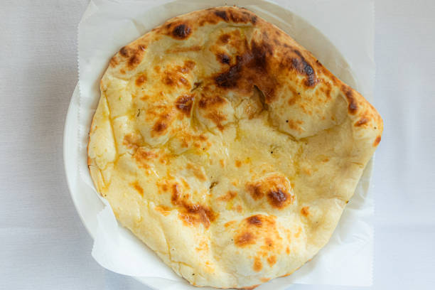 Plain Naan or sada khamiri roti served in plate isolated on table background top view of bangladeshi, indian and pakistani food