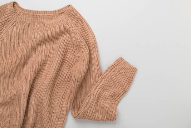 istock Beige knitted sweater on color background, top view 2161884045