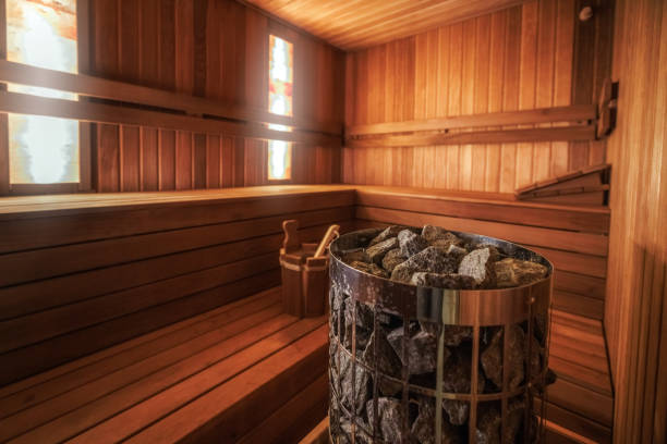Plastic green basin on a wooden shelf in the sauna.