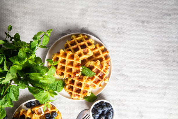 istock Belgian waffles with sour cream and blueberries in a plate 2161885321