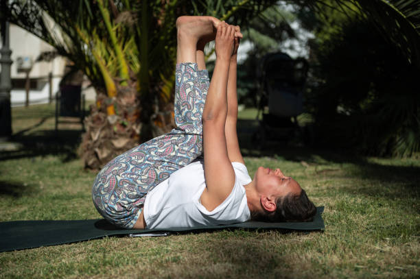 istock Woman practicing yoga pose outdoors in a sunny park 2161888313
