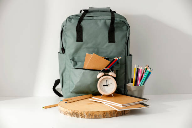 istock Backpack with school supplies and stationery on white table. Back to school concept. 2161890756