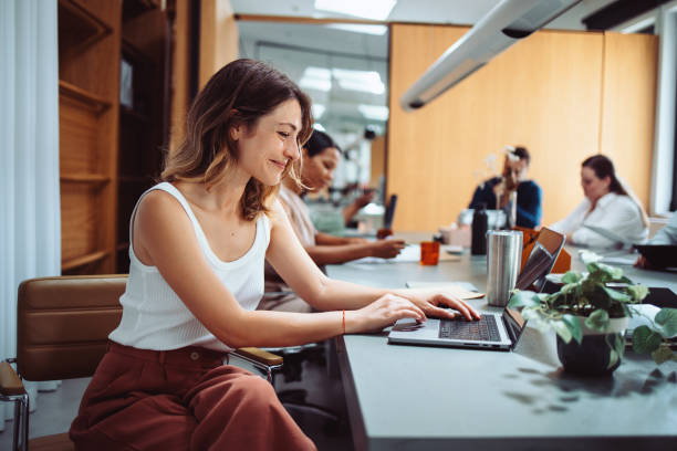 Young Woman Working on Laptop in Modern Office Setting