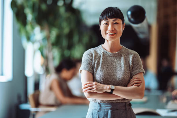 istock Confident Asian Businesswoman Smiling in Modern Office Setting 2161896269