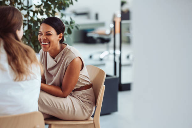 istock Two Women Laughing and Chatting in a Relaxed Office Setting 2161896317