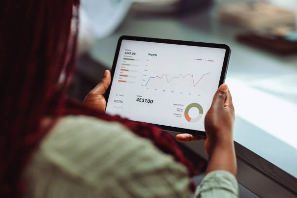Businesswoman Analyzing Financial Data on a Tablet Screen