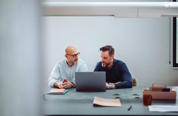 istock Two Businessmen Collaborating in Office with Laptop 2161896355