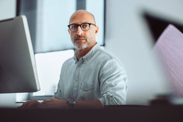 Focused Man Working at Office Desk with Computer, a Portrait (Copy Space)