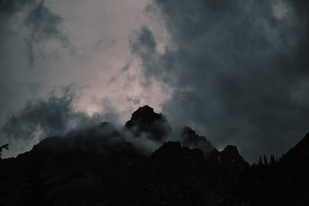 Rain clouds gathering above gloomy mountain peaks