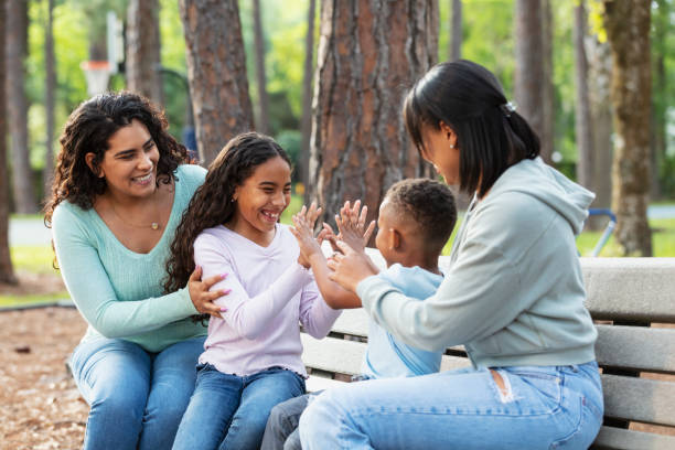 istock Two multiracial mothers, children playing on park bench 2161898830
