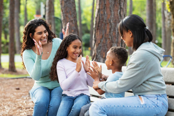 istock Two multiracial mothers, children playing on park bench 2161898834