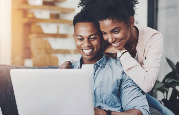 istock Black couple, hug and happy with laptop in home for remote work, reading email or scrolling social media on sofa. People, embrace and technology in living room for online browsing and watching movie 2161900274