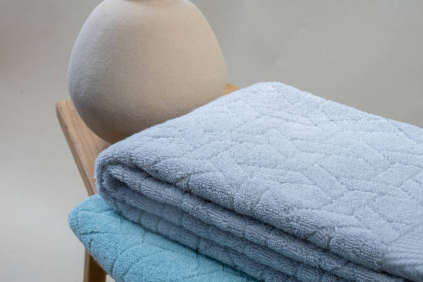 istock fluffy towels with a pattern in soft color on a neutral background on a wooden table 2161901404