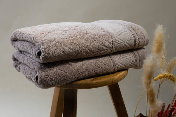 istock Folded Dark Gray Towel on Wooden Table with Neutral Background 2161901621