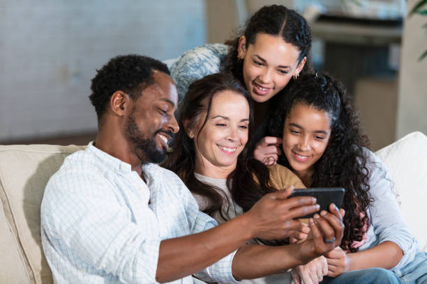 istock Multiracial family on sofa, father showing mobile phone 2161903048