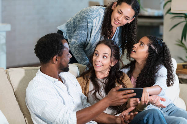 istock Multiracial family on sofa looking at mobile phone 2161903057