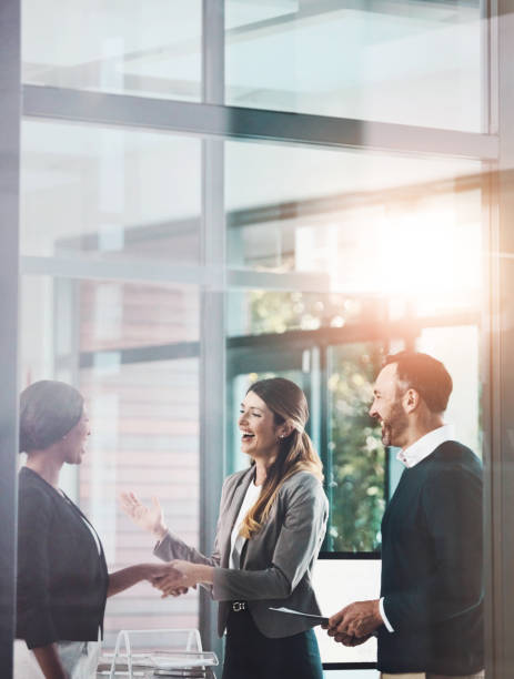 Business people, handshake and welcome in office with introduction for partnership, greeting or collaboration. Lens flare, diversity and employee with client shaking hands for deal, b2b or agreement