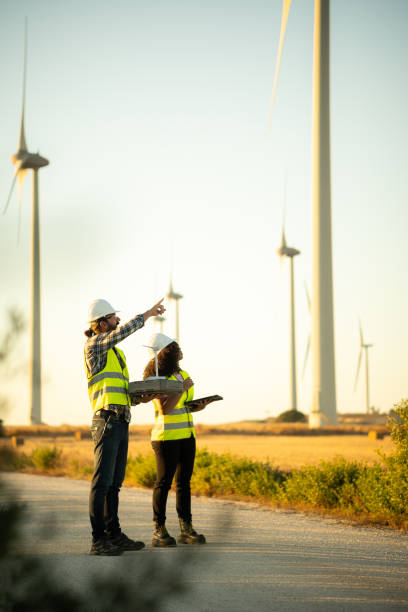 istock Engineers working at windmill power plant using digital tablet and holding model 2161922961