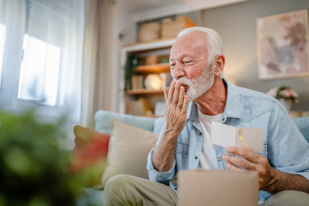 istock one senior man open box presents and read card while on video call 2161925954