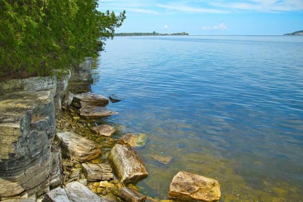 Sunny Summer landscape of a lush green forest bordering Lake Michigan beneath a bright blue sky near Sturgeon Bay, Wisconsin.