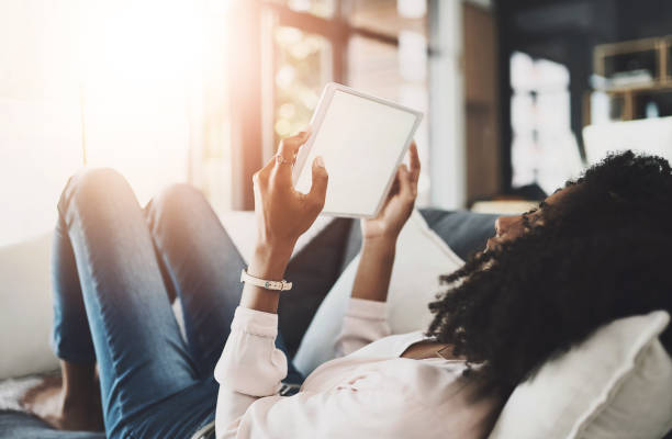 istock Black woman, sofa or relax with tablet screen or mockup for internet research, reading lifestyle or blog for ideas. Female person, couch or ebook with website for plan in home, scroll for information 2161930650