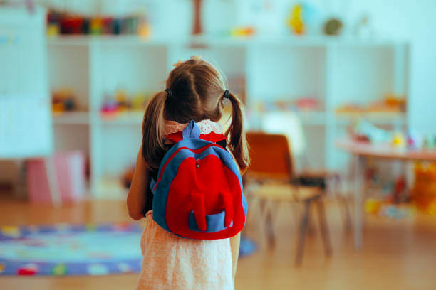Little girl entering the classroom going back to school