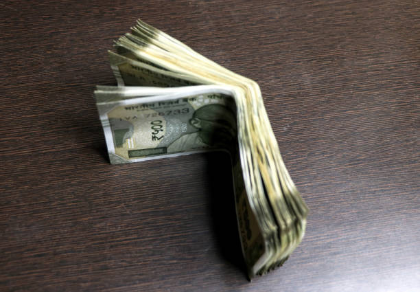 Cut out of Indian ten Rupees currency paper note cash spread out, weathered old 10 rupee captured from the front, isolated over horizontal white background