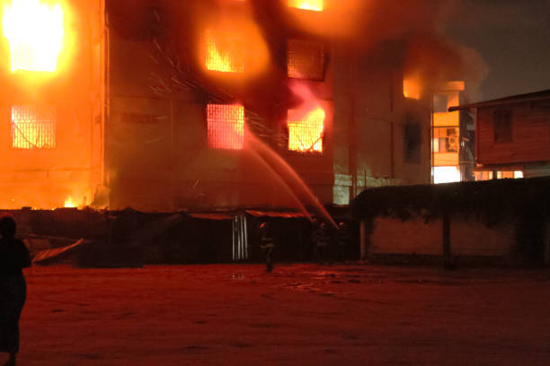 Burning Building with Silhouettes of Firemen Fighting a Fire.
