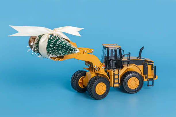 istock Christmas tree with  wheel loader model lift up. 2161942906