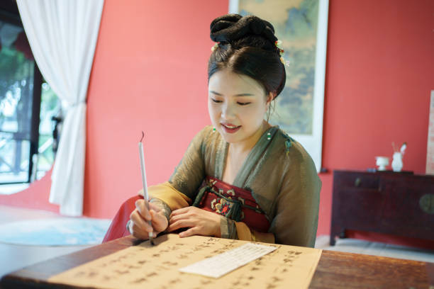 A woman experiencing Chinese Hanfu is writing calligraphy