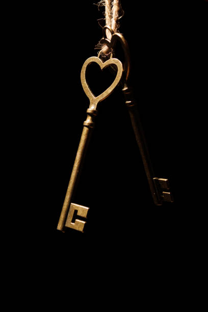 Bronze house key and red country fabric heart  old wood, Valentines Day, real estate and home concept background with wooden painted copy space.