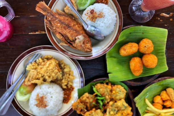 istock a packet of rice, fried fish with fresh vegetables (nila goreng) and fried chicken rice ( ayam kremes) 2161946952