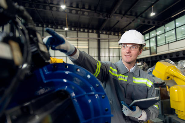 istock Engineer standing by robotic arm and operating machine in industry factory 2161950990