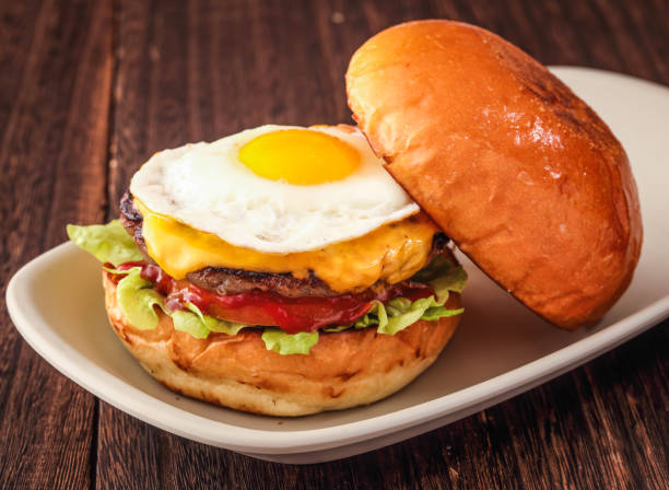 Angus Cheese Egg Burger with tomato, lettuce leaf served in dish isolated on background side view of hong kong fasfood