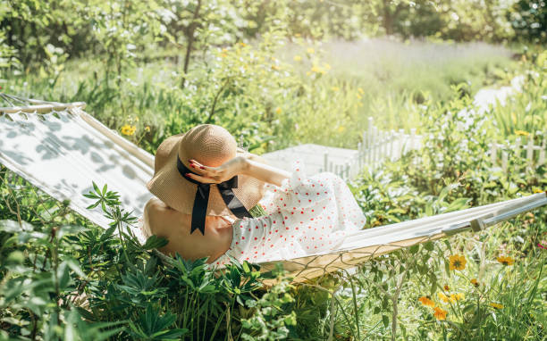 Young woman relaxing in a hammock outdoors in back yard