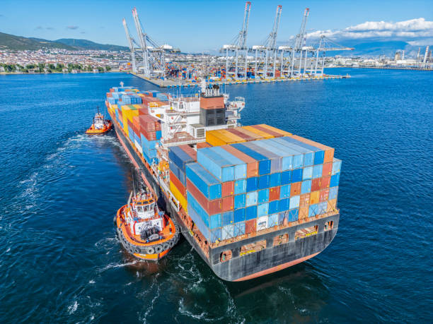 istock Aerial view of Cargo Container Ship approaching port with tugboat. 2161957779