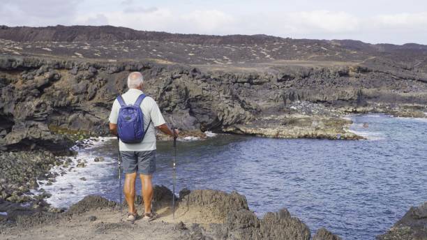 istock Ocean Contemplation: Senior man from Behind on Rocky Coastline 2161958113