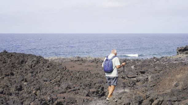 istock Elderly pensioner walking on the volcanic coast 2161958128