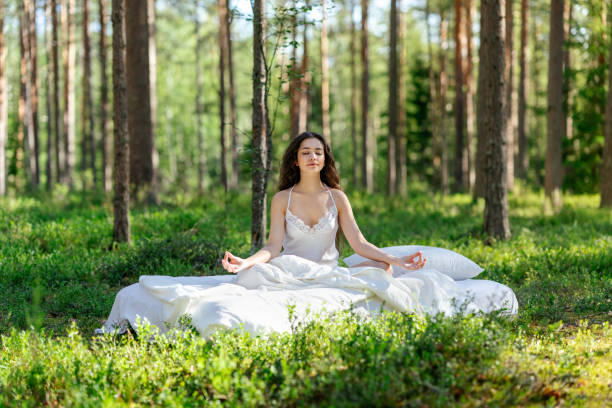 istock Young woman is sitting in the forest on a white bed 2161959969